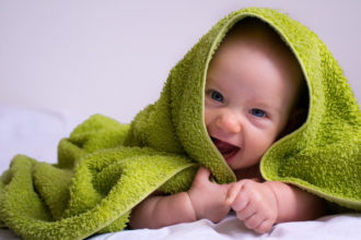 Lachendes Baby unterm Handtuch